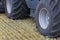 The wide wheels of the combine roll over the stubble of the harvested field