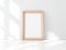 Wide Wooden photo Frame Poster Mockup standing in white room