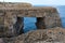 Wied il Mielah canyon, natural arch over the sea. Gozo, Malta