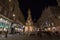 Wiener Pestsaule, also called the Plague Column, on Graben street, at nights, with pedestrians passing by. It`s a baroque landmark