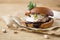 Wierd burger with vanilla ice cream and chocolated confetti on wooden background.