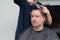 Wife cuts the hair on husband at home during quarantine amid COVID-19 coronavirus pandemic