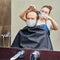 Wife cuts a man in medical mask hair with scissors in front of the mirror. The concept of grooming and problems with appearance