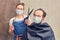 Wife hairdresser in medical mask makes haircut to husband with garden scissors, funny concept