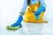 Wife housekeeping and cleaning concept, Happy young woman in blue rubber gloves wiping dust using a spray and a duster while