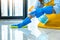 Wife housekeeping and cleaning concept, Happy young woman in blue rubber gloves wiping dust using a spray and a duster while