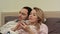 Wife and husband watching funny movie, discussing, woman using smartphone