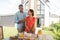 Wife putting bowl with cookies on table on summer terrace