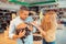 Wife smiling while touching grey cat in hands of her husband