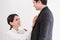 Wife tying red necktie to her husband in the office with smiling and happy