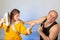 A wife in a yellow robe beats a bald husband, the concept of a family quarrel