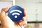 Wifi icon blue round button holding by hand infront of workspace background