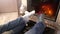 Wiggling legs in woolen socks heat up near fireplace