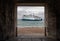 Wightlink ferry en route to the Isle of Wight framed through a gate in the ancient harbour ramparts in Portsmouth, Hampshire, UK