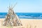 Wigwam Made from wooden branches on the sand of baltic sea beach