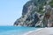 Wild beach on the Mediterranean coast. Empty pebbles beach, turquoise sea and rocks.