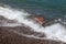 Wild beach on the seashore. Big wave. Large stone under water. Concept - Diving and swimming in unequipped places. The danger of