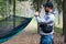 Wild camping in nature in Estonia. A man attaches a hammock to a tree in a spruce forest