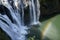 Wild cascade between stones in forest landscape