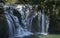 Wild cascade between stones in forest landscape