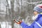 Wild chickadee bird landing on a womans hands in snowing winter, New England, US