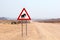 Wild desert elephant warning road sign, Himba people huts, Namibia