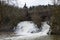 wild Elz waterfall during snow melting season with the old bridge