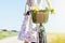 Wild flowers bouquet carried by young woman in dress with flowers in bicycle basket