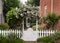 Wild flowers growing over white picket fence