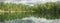 Wild forest lake, panoramic view. Gloomy sky, beautiful reflection