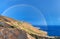 Wild hilly coastline of Creta island with a rainbow, panoramic image