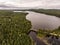 Wild huge pine tree forest and lake divides old wooden bridge in Canada Camping