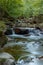 Wild motion mountain river with waterfalls over wet rocks in a forest nature landscape