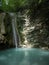 Wild nature with trees, plants, stream, waterfalls and rocks. A small stream in the gorge of the mountain canyon in the summer