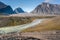 Wild Owl River winds through remote arctic landscape in Akshayuk Pass, Baffin Island, Canada. Moss valley floor and