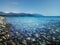 Wild pebble beach view with blue sky and mountains