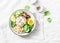 Wild rice, boiled egg, spinach, avocado puree, beans, tomatoes buddha bowl on light background, top view. Healthy vegetarian food