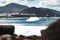 Wild rocky coastline of surf spot La Santa Lanzarote, Canary Islands, Spain. Surfer riding a big wave in rocky bay