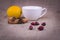 Wild rose, cinnamon sticks, anise and lemon on the background of burlap with a white cup