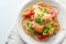 Wild salmon fillet on whole grain spaghetti with broccoli, tomatoes and parsley garnish, healthy meal on a white plate, copy pace