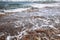 Wild stone beach and sea waves crashing on the rock and making a  water mesh with bubble