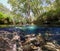 Wild stream landscape over and under water surface with rocky riverbed