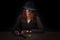 wild west girl with revolver gun sitting at the table with ammunition and silver coins