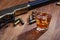 Wild west rifle and ammunitions with glass of whisky and ice on wooden table