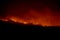 Wildfire disaster - fire burning mountain in night time