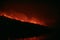 Wildfire disaster - fire burning mountain in night time