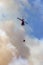 Wildfire Service Helicopter flying over BC Forest Fire and Smoke on the mountain near Hope