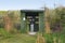 Wildlife observation blind with woman photographing animals in nature with her cell phone