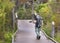 Wildlife Photographer with telephoto zoom lens walking swamp boardwalk wearing camouflage