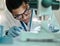 This will all make sense in the end. a young scientist using a microscope in a lab.